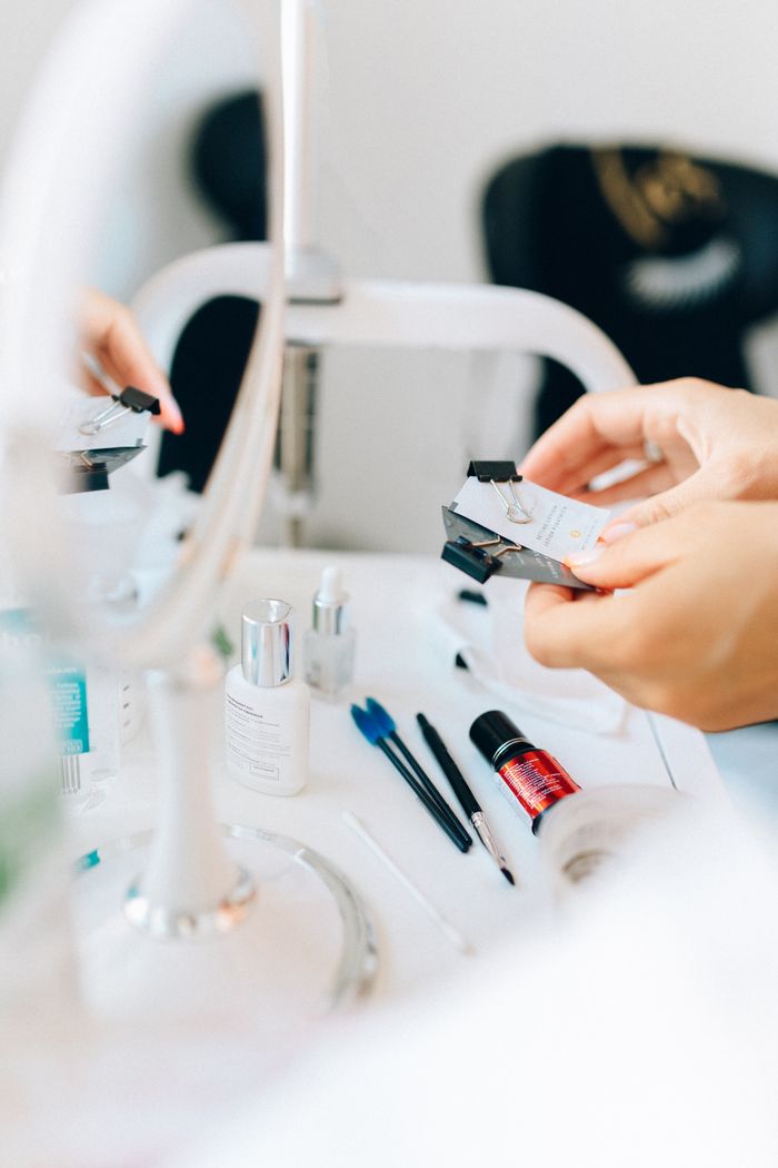 Close-up of a neatly arranged vanity with cosmetics and beauty tools, reflected in a mirror.